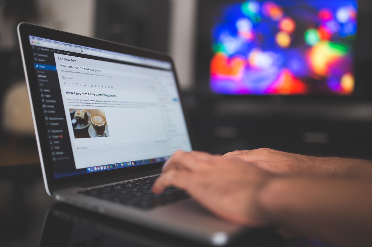 Person typing a blog post on a laptop
