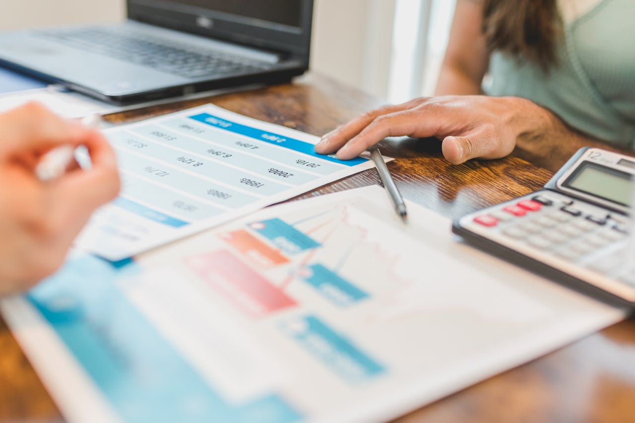 Financial advisor and client reviewing documents at desk